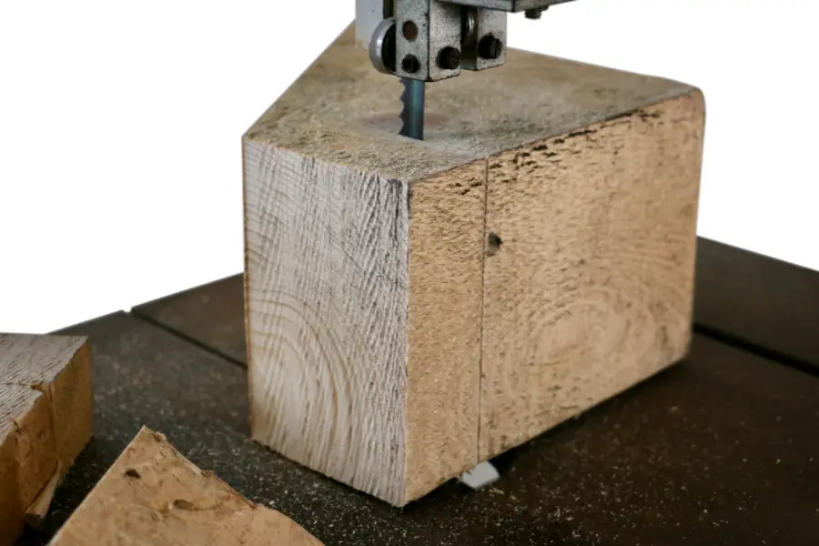 band saw blade cutting through a natural wood timber log