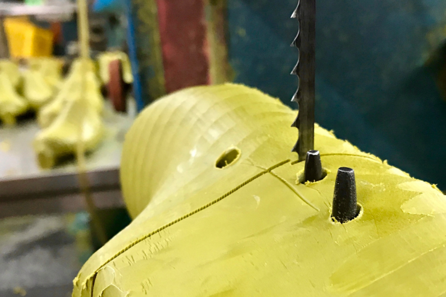Precision band saw machine slicing dense rubber and plastic block