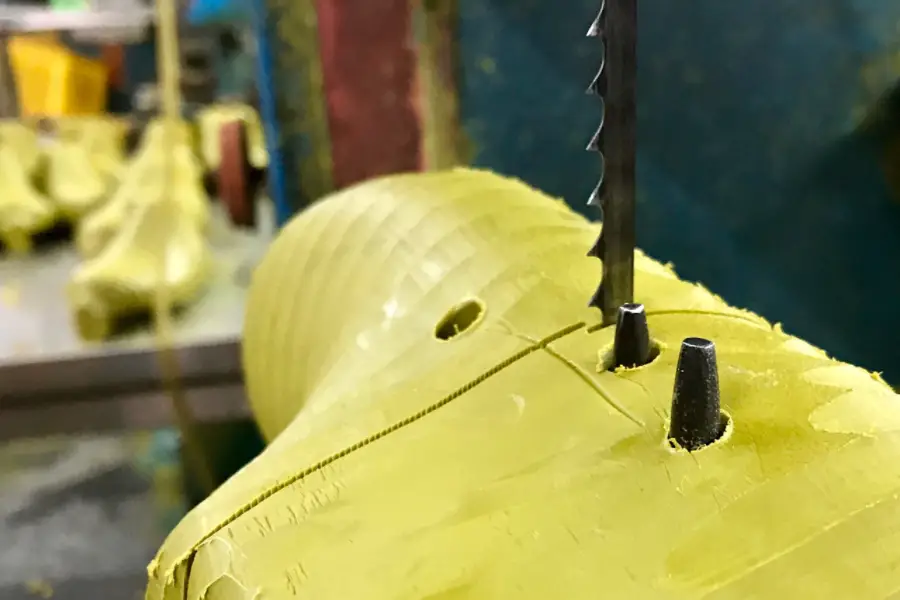 Precision band saw machine slicing dense rubber and plastic block