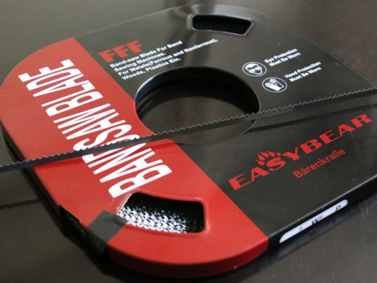 Boxed carbon steel band saw blade with an unboxed coil on top showing tooth profile and blade details
